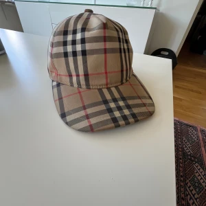 Burberry keps - Hej! Säljer denna jätte snygha burberry kepsen i size L. Det är en äkta vara. Färgen på kepsen ser lite ljus ut men detta är bara pga det starka ljuset.  För mer frågor är det bara att kontakta mig privat. Kan gå ner i pris vid mkt snabb affär Mvh