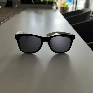 Ett par svart vita Vans solglasögon 