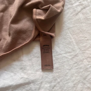 Skims bodysuit - En beige/brun skims bodysuit i storlek xxs/xs, använd fåtal gånger så nästintill ny. Nypris 985kr men jag säljer för 450kr