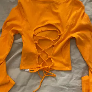 Fin orange topp med snördetalj i ryggen, perfekt till sommaren. Strl M. Ser ut som produktbilderna på bara de att de är en annan färg. Aldrig använd.