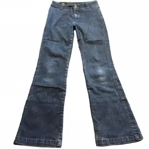 Unika mörkblå jeans från lee! Midrise/högmidjade, i 70tals stil utan fickor! Midjemått 67,5cm Innerbenslängd 73cm Grenhöjd 24cm