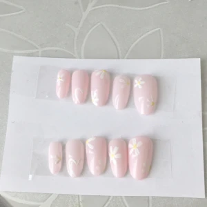 Press on nails  - Press on nails (lösnaglar). 💗Ljus rosa lösnaglar med vita blommor och vita hjärtan på. 🤍💅🏻Handmålade och kommer med en liten nagelfil och nagelklister. Köparen står för frakt (Skriv om det är frågor).💕