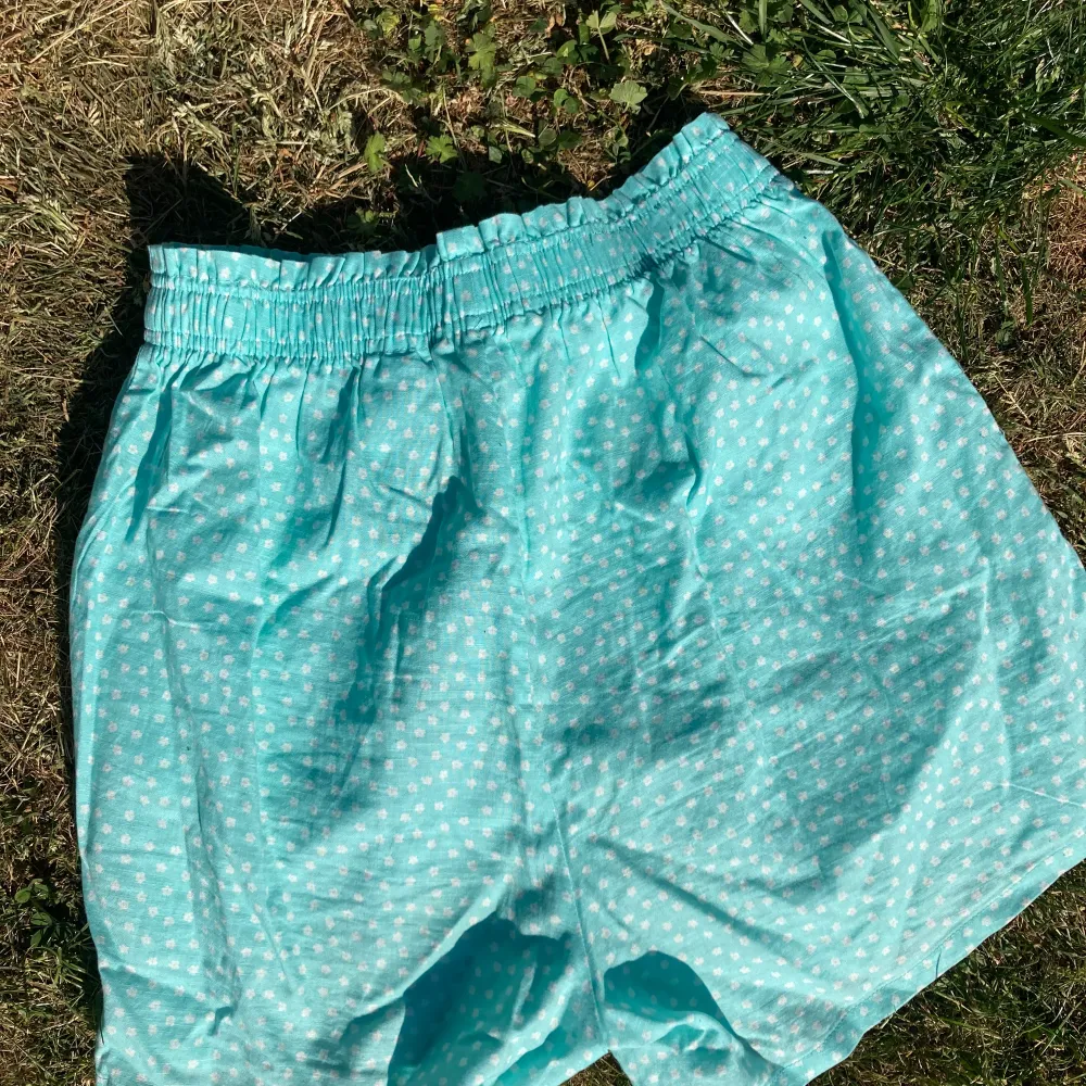 Ett par turkosa shorts med små vita blommor på. De är från H&M i storlek 164. Kontakta om du är intresserad!🥰. Shorts.