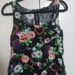 Blommig blus - Svart blus med blommor, superfin till sommaren och i bra skick.   Köparen står för frakt 💕