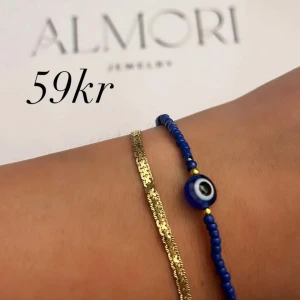 Två armband från Almori - handgjort armband från Almori blått med små pärlor och ett öga i mitten.