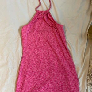 Rosa klänning  - Rosa klänning med snören runt halsen.