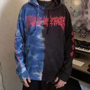 SHIBORI THREADS x CRADLE OF FILTH - Tie Dye hoodie sz L - SJUKT unik hoodie med 3-panelstryck från exklusiva Shibori Threads. Gjorts i sjukt limiterad upplaga, går inte att få tag på i efterhand. Tog 4 månader bara att få den gjord och levererad. Ett måste för alla CoF-fans!! Jag på bild är 175cm 🥀🥀🥀