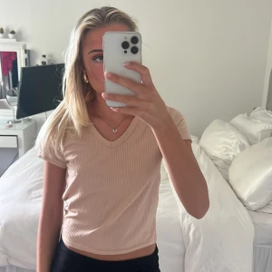 T-shirt  - Ribbad, kort, v-ringad t-shirt i mjukt material. Använd 1 gång