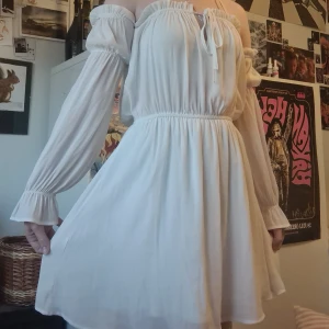 Vit sommarklänning - Superfin, tunn & vit sommarklänning. Säljer pga att det inte är något jag använder. Den är ursprungligen från NELLY.com och är justerbar i bysten genom snören som knyts där fram🫶 Bara använd 2 eller 3 gånger!