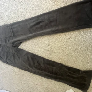 Juicy byxor - Säljer nu dessa så fina juicybyxor i mörkgrå som är anvönda ett fåtal gånger men inget som syns förutom runt midjan där bandet tappet en metallsak (se bild 2)