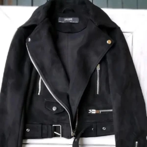 Snygg Zara jacka  - Snygg svart jacka från Zara med dragkedjor och avtagbart bälte. Bikerjacka i mockaimitation, storlek XS. 