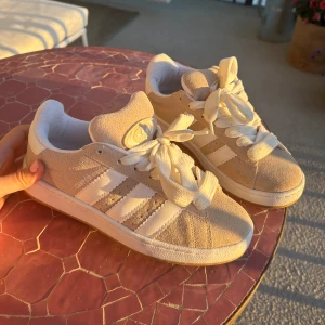 Adidas Campus 00 beige - Galet snygga beiga campus! Säljer då de tyvärr är för stora för mig 🥲. De är knappt använda av mig o är i bra skick (med några små fläckar såklart eftersom de ej är i nyskick). Går nog att tvätta bort lätt! Köpta på plick! 😍🥰 