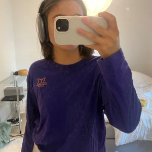 Långärmad tshirt - Långärmad tshirt i lila färg och ett litet tryck på framsidan! 