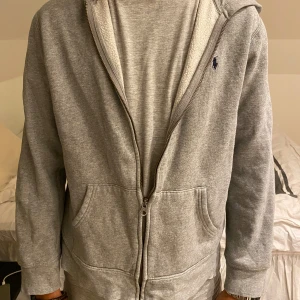 Ralph Lauren zip hoodie - Grå Ralph Lauren zip hoodie. Använd ett antal gånger men är i jättebra skick utan fläckar eller hål eller likande. Funkar för både killar och tjejer som ni ser på bilderna!