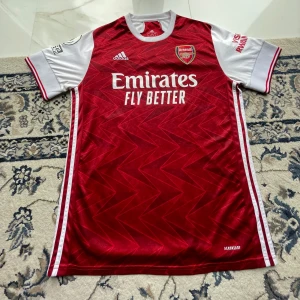 Arsenal 20/21 hemmatröja adidas  - Säljer en arsenal 20/21 hemmatröja i toppskick använd kanske 2-3 gånger. Tyvärr inget spelar namn eller nummer där bak.   Väldigt fin tröja för sommaren till bra pris🔥  Meddela mig vid frågor!