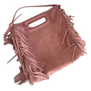 En äldre modell av majes m bag i mocka! Äldre modell av Maje m bag i suede i ”dirty Pink” i större modellen. Använd flitigt men inga stora skador förutom möjligtvis lite småfläckar på mockan. Köpt för ca 2600, mitt pris 1800. Kan skicka fler bilder! 