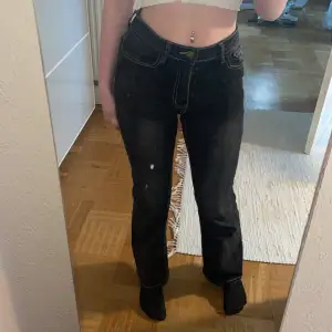 Svarta utsvängda jeans med mönster på fickorna