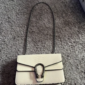 Vit väska🩷 - Jag säljer min vita väska med en fin drakdetalj på framsidan🩷 Den har 3 fack varav ett har dragkedja.