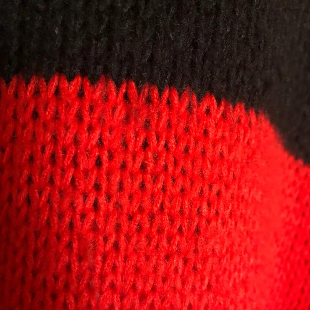 En röd svart stickad tröja. Den är storlek S och Oversized.. Tröjor & Koftor.