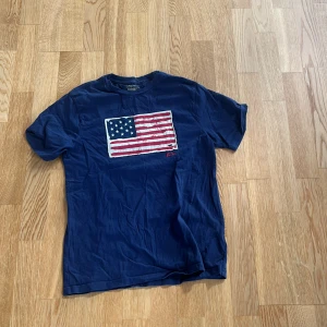 Polo t-shirt  - Blå tröja med usa flaggan på i bra skick 