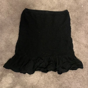 Svart volangkjol från bikbok - Säljer denna korta volangkjolen från Bikbok då den inte kommer till användning längre! Perfekt för sommaren ☀️ den är i bra skick förutom att den har typ 2 mörka prickar som ej går bort, men inget som man tänker på! Därav pris pga prickarna