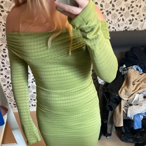 Off-shoulder klänning  - En lång grön off the shoulder klänning från collusion i storlek 36. Använd en gång. Bra skick.