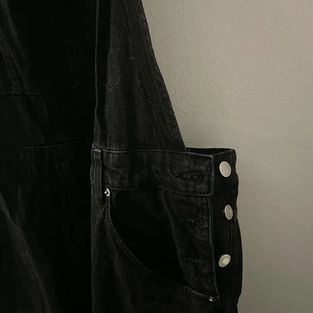 Hängselbyxor svart stentvättade i jeans material, med silver detaljer. Strl. XXL Normal/ mindre i storleken. Aldrig använda endast testad.. Jeans & Byxor.