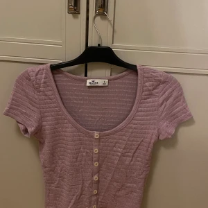 Topp - Jätte söt rosa topp från hollister. Den är i ribbat material och har knappar på sig. Är i bra skick💗.