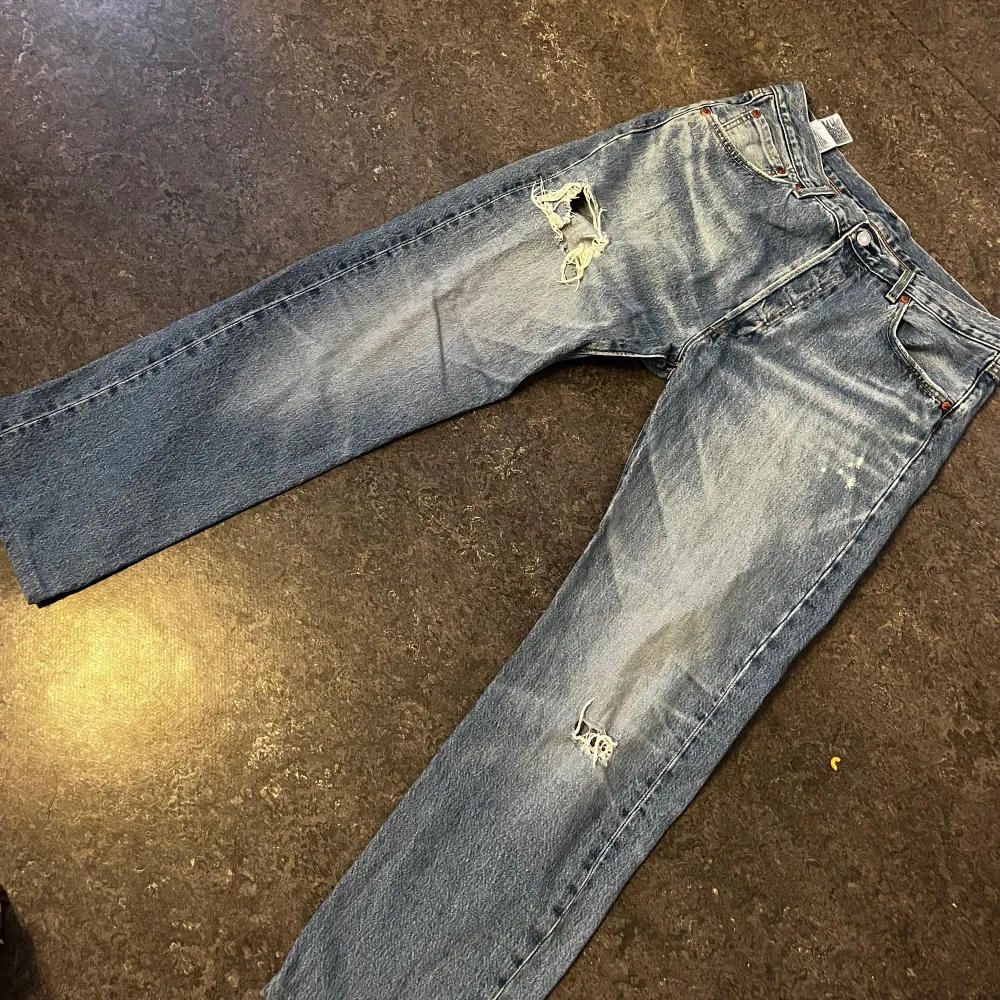 Levis jeans med hål  Ett par snygga Levis jeans som säljs pga ny stil. Användes i ca 4 månader  Lite trasiga längst ner på byxan  Ett litet hål på baksidan av jeansen . Jeans & Byxor.