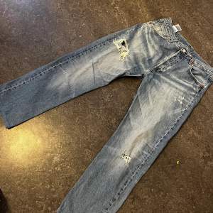 Levis jeans med hål  Ett par snygga Levis jeans som säljs pga ny stil. Användes i ca 4 månader  Lite trasiga längst ner på byxan  Ett litet hål på baksidan av jeansen 