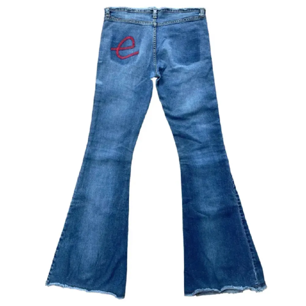 Så snygga lågmodjade bootcut jeans med broderat rött e på baksidan  Midja- ca 74 cm Innerbenslängd- ca 83 cm. Jeans & Byxor.