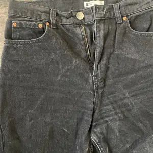 Jeans med svart tvätt, i modellen ”momjeans”. Två fickor framtill samt två fickor baktill.