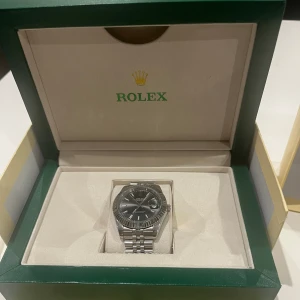 Rolex datejust klocka  - Hejsan dags att sälja min Rolex datejust i färgen grå. Allt medföljer i bilderna och det finns en Rolex påse också så klart. Har används 2 gånger och är sprillans ny. Priset går inte ner tyvärr, serie nummret finns i klockan  Mvh Hugo 
