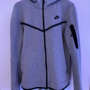 Nike Tech Fleece Grå - Nike Tech Fleece tröja i storlek M, säljs då den inte används längre. Tröjan har använts en del men är fortfarande i bra skick.