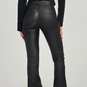 Coated utsvängda jeans från Nelly - Helt nya jeans från Nelly. Aldrig använda och prislapp kvar. Medel midja  Storlek S/30   Midjemått: 65  Innebenslängd: 69   Nypris 499kr