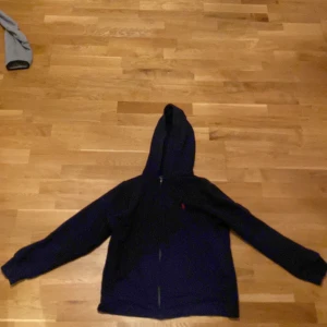 Polo raulph lauren kofta med ett märke på ryggen av den anledningen är denna tröja billig - Skick 5/10 ett mellan stort bränn märke på ryggen som knappast är synlig efter som tröjan har en mörk färg annars är den använda ungefär 5-7 gånger