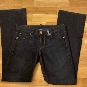 Lågmidjade bootcut jeans från Armani Exchange. Innerbenslängden är 80 cm och midjemåttet 42cm rakt över. W27/L34