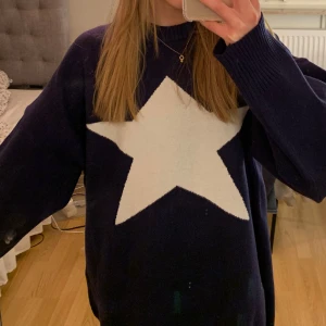 Tröja med stjärna - Trendig marinblå stickad tröja med vit stjärna på. Det står inget märke på den. Pris kan diskuteras vid snabb affär.