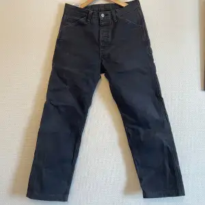 Worn, slightly distressed and faded. Rigid fabric. Size 30/32 tts.
