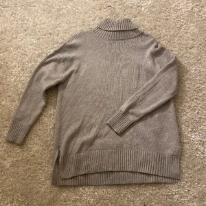 Grå stickad  - En grå stickad tröja som är lite längre i modellen. Bra skick!