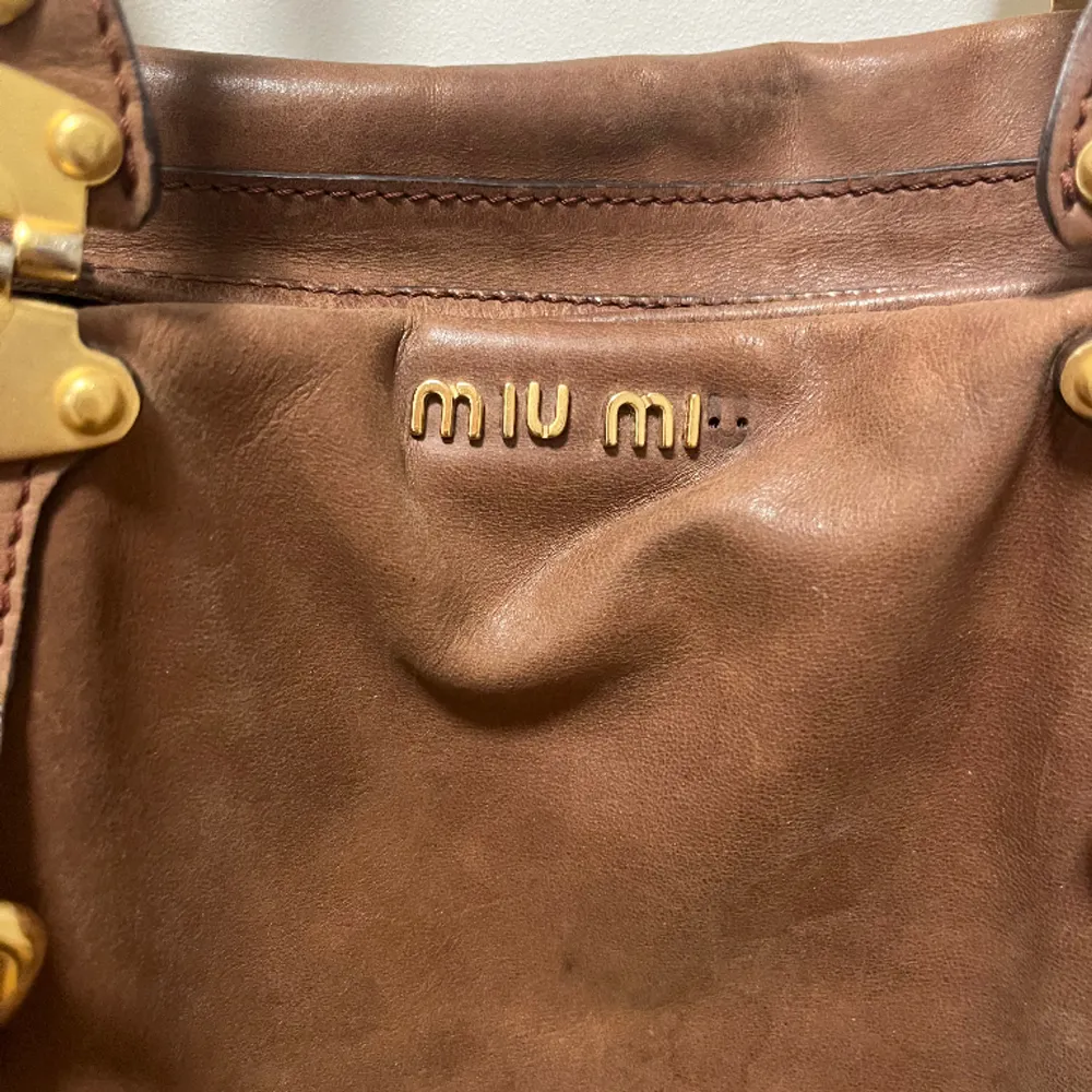 Säljer denna super fina Miu Miu väska!💕 Den är ganska sliten, därav priset och en av bokstäverna har trillat av (se andra bilden). . Väskor.