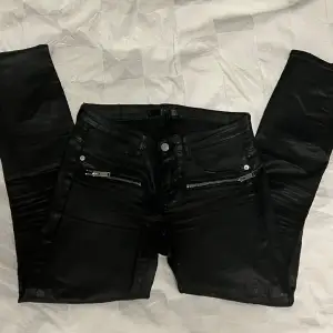 Svarta jeans med lackad yta, blixtlås i benslut