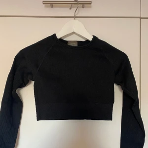 Croppad träningstopp  - Croppad svart träningstopp från aimn i ribbat material. Storlek S men passar även som XS. Oanvänd.