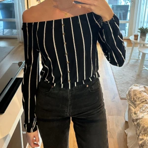Fin offshoulder topp - Randig off the shoulder topp i marinblå och vit med knappar längs mitten där fram