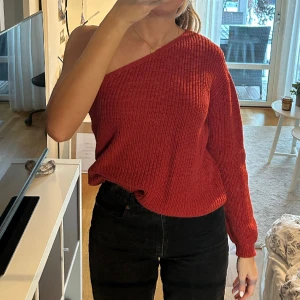 One shoulder stickad tröja  - En supersnygg stickad one shoulder tröja i en fin ”rostfärg”. Bara använd fåtal gånger 