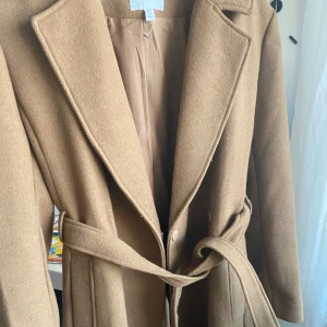 Beige kappa - Inte alls använd ljus brun/ beige kappa nyligen köpt från HM. Färgen föll mig inte riktigt i smaken när jag kom hem med den, tycker någon annan kan få användning av den😊💕