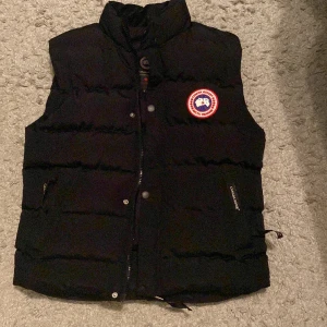 Svart canadagooseväst. - Hejsan, Jag säljer nu min helt nya canadagooseväst. Den är helt oanvänd och de är en lusthentic kopia. De finns nästan ingen skillnad på lusthentich och en äkta. Ny pris låg på 2300kr. Säljer den nu för 1600kr. Kontakta om ni är intresserade!