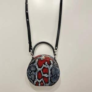 Röd/blå rund väska från Rebecca Minkoff i pytonprintat läder.   Avtagbar axelbandsrem.   Använd ett fåtal gånger, i väldigt gott skick 