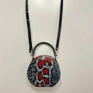 Rebecca Minkoff väska  - Röd/blå rund väska från Rebecca Minkoff i pytonprintat läder.   Avtagbar axelbandsrem.   Använd ett fåtal gånger, i väldigt gott skick 