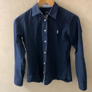 Polo Ralph lauren skjorta  - Skjortan passar 160-170cm. Och jag är 168cm. Så den är lite för liten. Storleken är S men det passar XS. Modell-Slimfit .den är fri ifrån defekter och hål. 9/10 i skick. Hör av er vid funderingar eller övrigt mvh Alex 